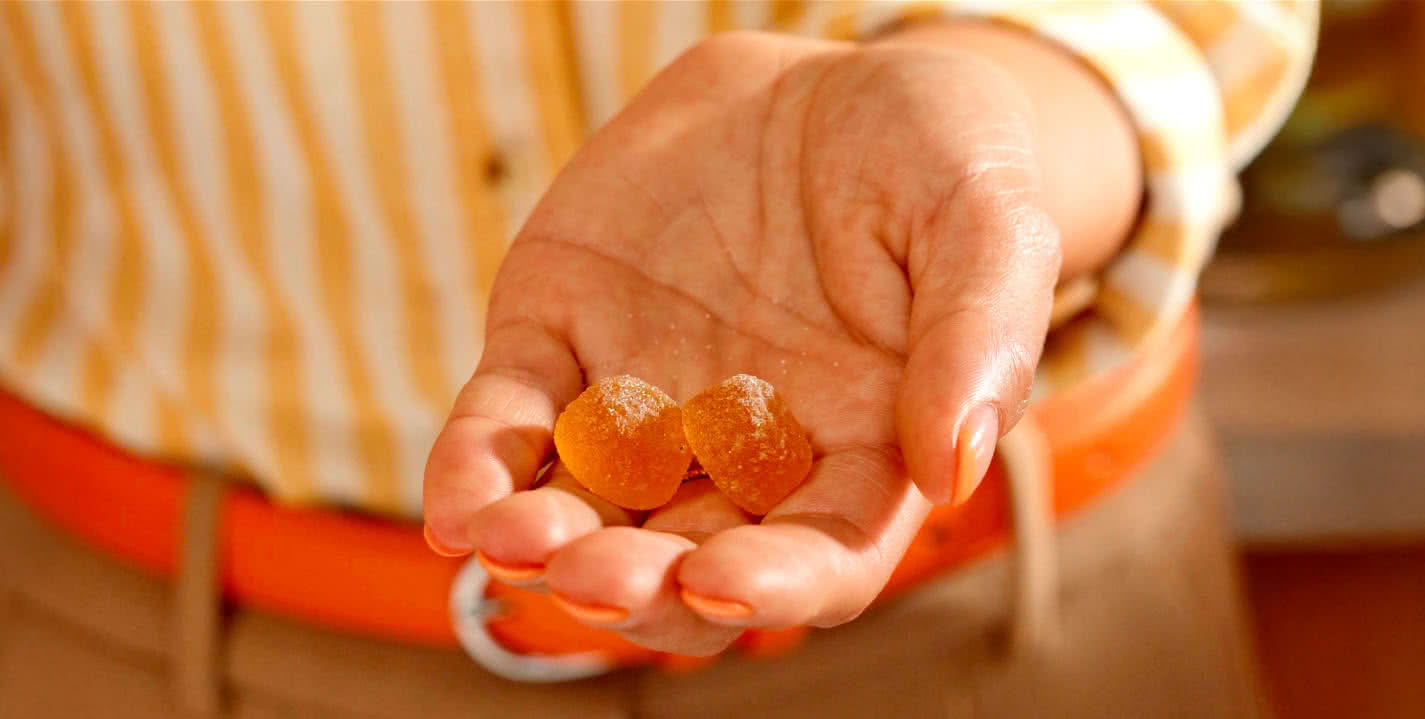 hand holding two OLLY probiotic gummies