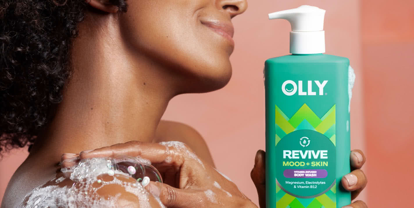 Woman holding OLLY REVIVE MOOD + SKIN Body Wash